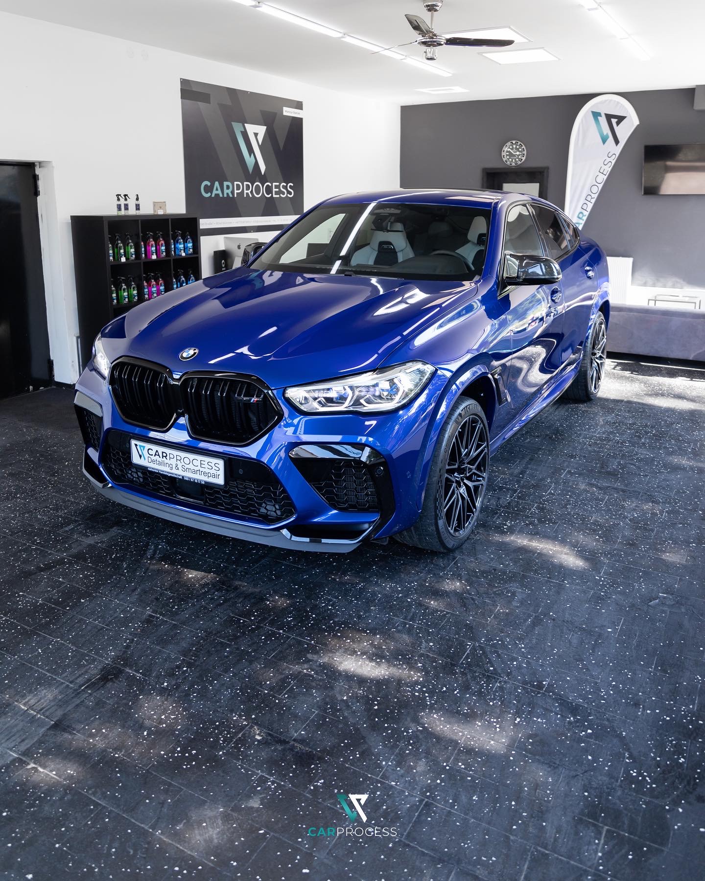 BMW X6 M Competition in Blau frontal im Show-Room